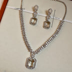 Silver necklace and earrings with gemstones on a beige background