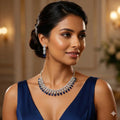 Woman wearing a blue dress and silver jewelry set with a blurred background
