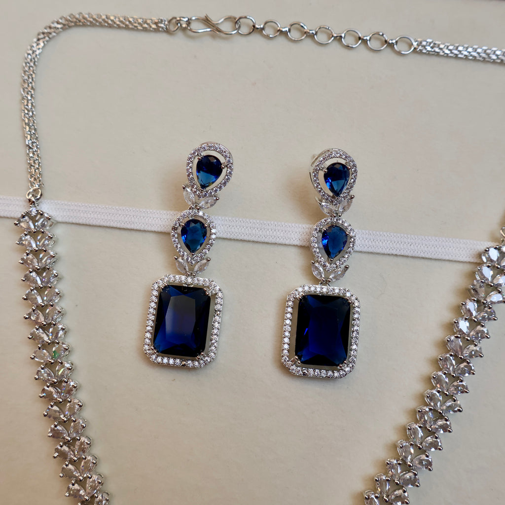 Jewelry set with blue gemstones and silver accents on a white background