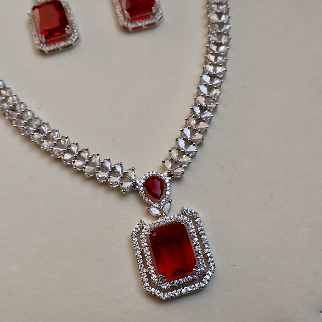Necklace with red gemstones and diamond-like accents on a light gray background