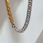 Two braided chain necklaces, one gold and one silver, on a light gray background.