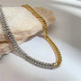 Gold and silver chain necklaces on a textured surface