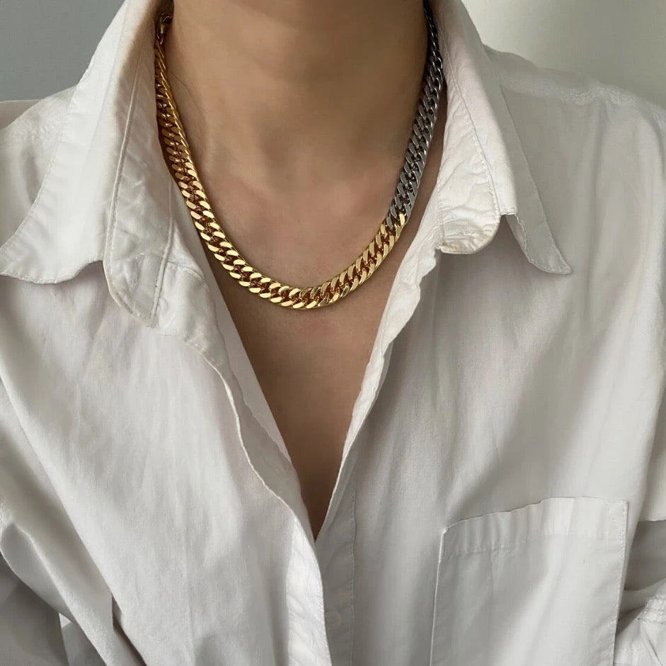 Gold chain necklace worn by a person in a white shirt