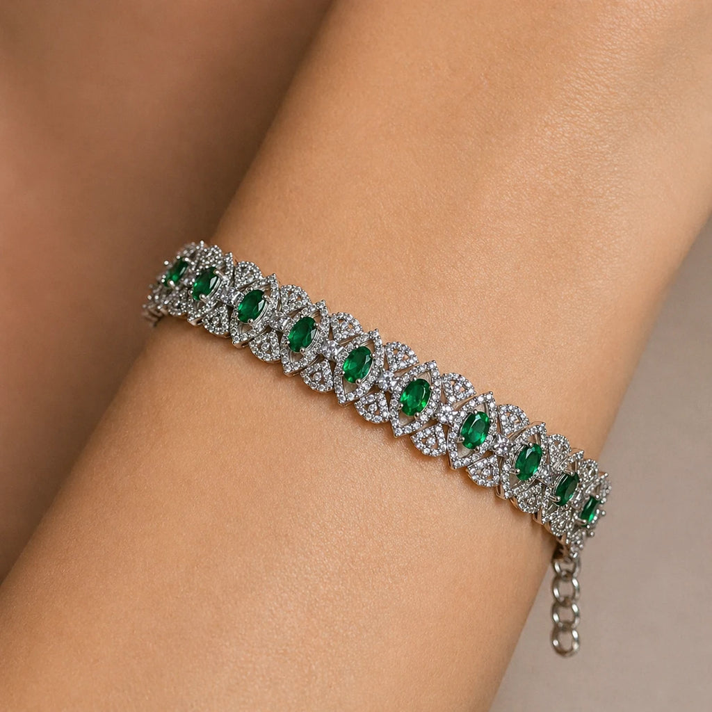 Bracelet with green gemstones on a wrist against a neutral background