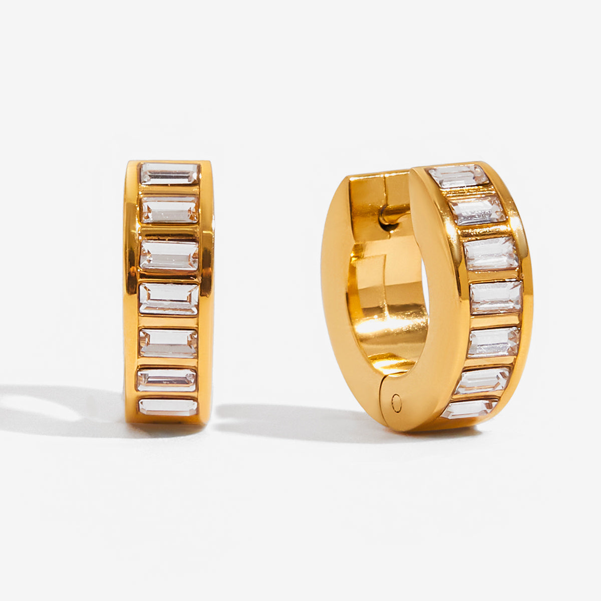 Gold hoop earrings with embedded stones on a white background