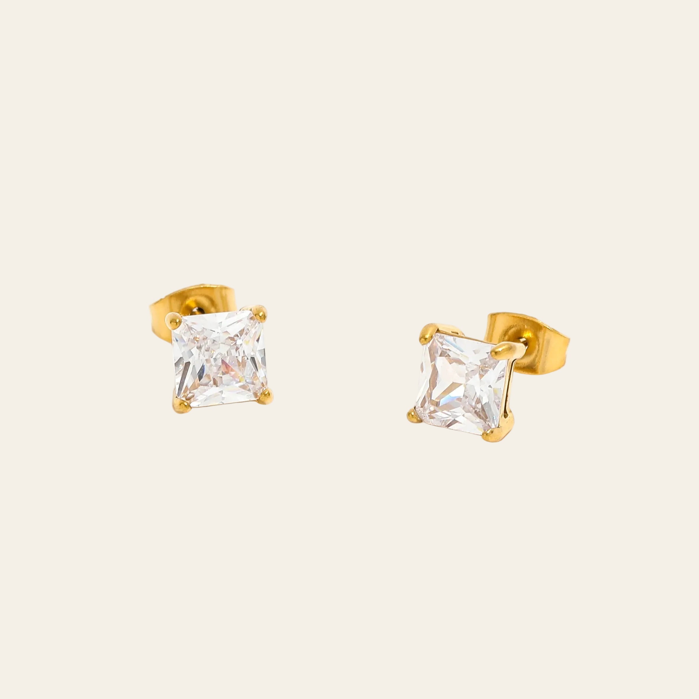 Gold stud earrings with clear gemstones on a white background