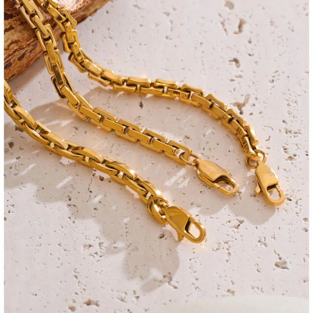 Gold chain necklace on a textured surface
