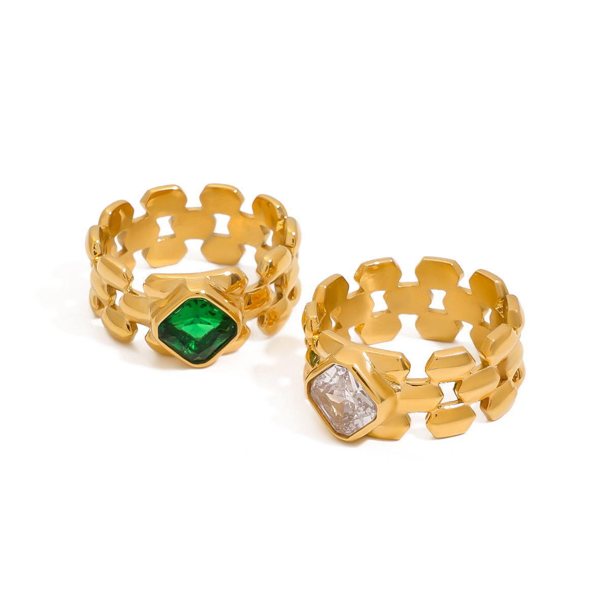 Two gold rings with gemstones on a white background
