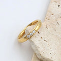 Gold ring with small diamonds on a stone surface