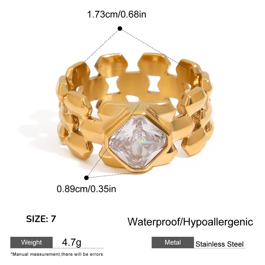 Gold ring with geometric design and clear gemstone, showing measurements and material details.