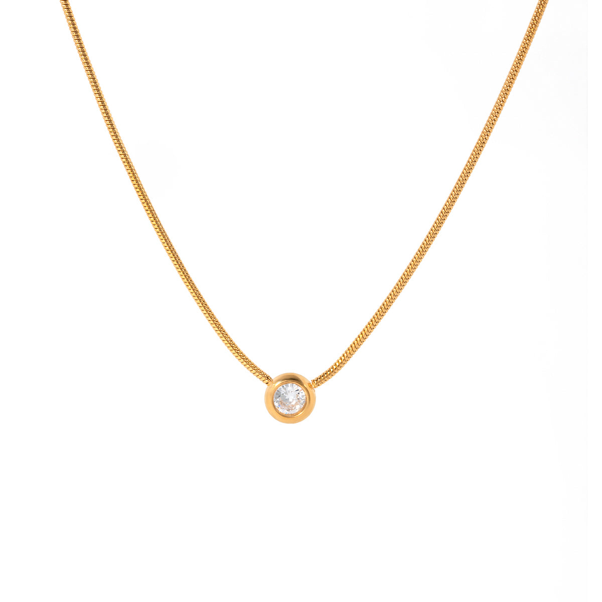 Gold necklace with a small round pendant on a white background