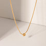 Gold necklace with a round pendant on a light beige background