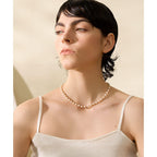 Woman wearing a pearl necklace against a beige background