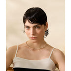 Woman wearing a pearl necklace against a beige background