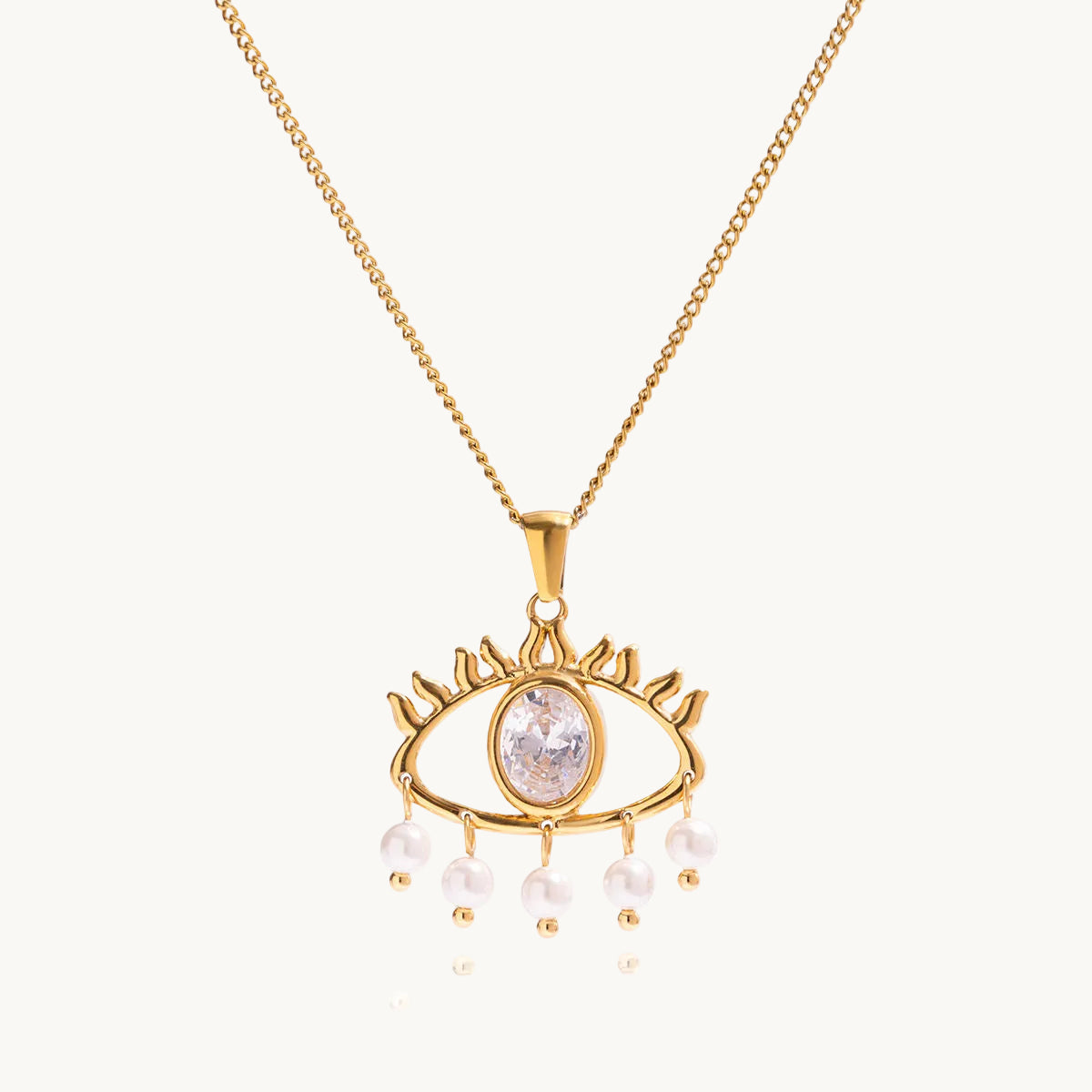 Gold necklace with an eye-shaped pendant and pearl accents on a white background