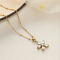 Gold necklace with a butterfly pendant on a light background