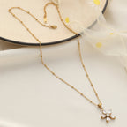 Gold necklace with a small pendant on a white surface