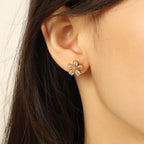 Close-up of an ear wearing a floral earring with a blurred background