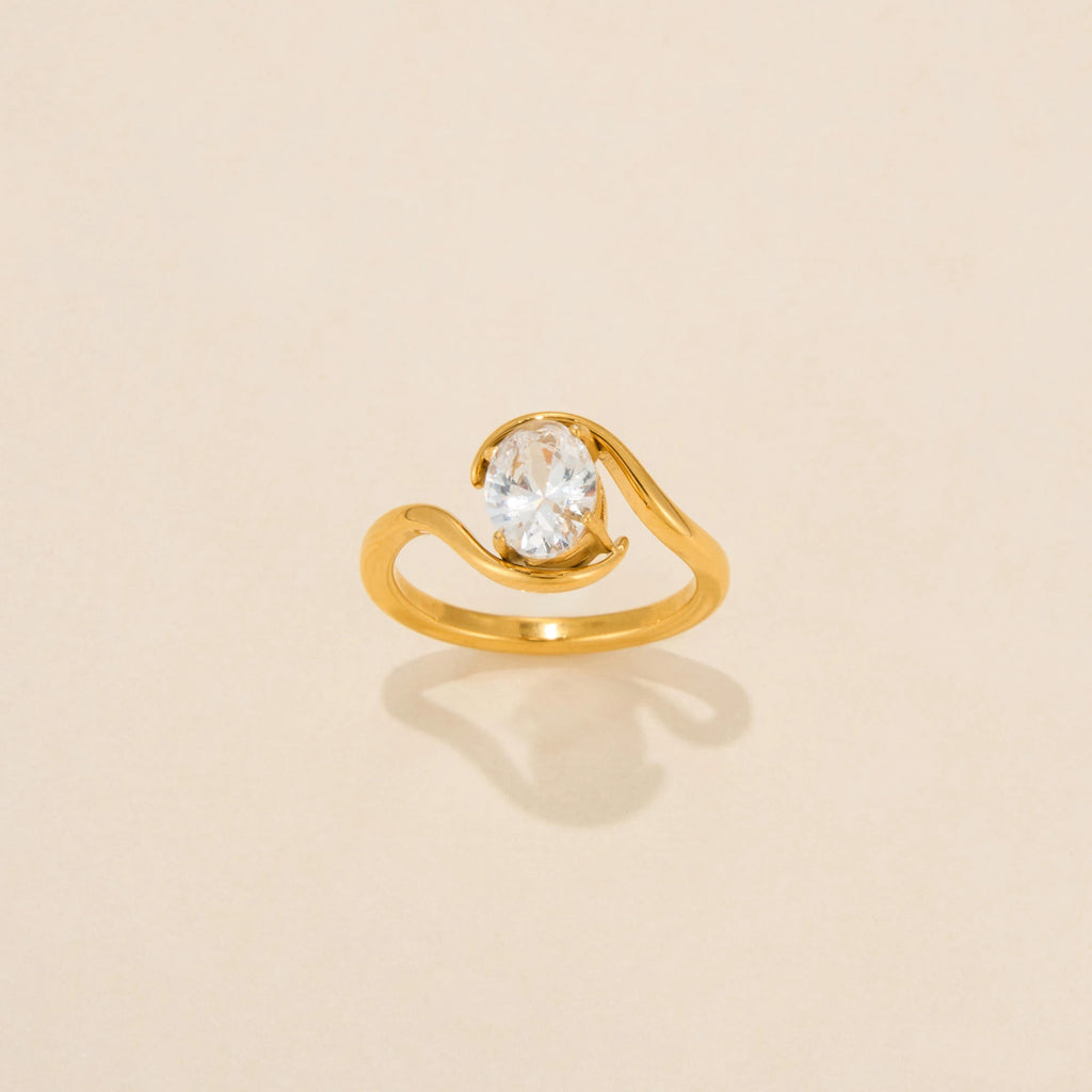 Gold ring with a diamond on a beige background