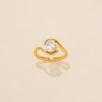 Gold ring with a diamond on a beige background