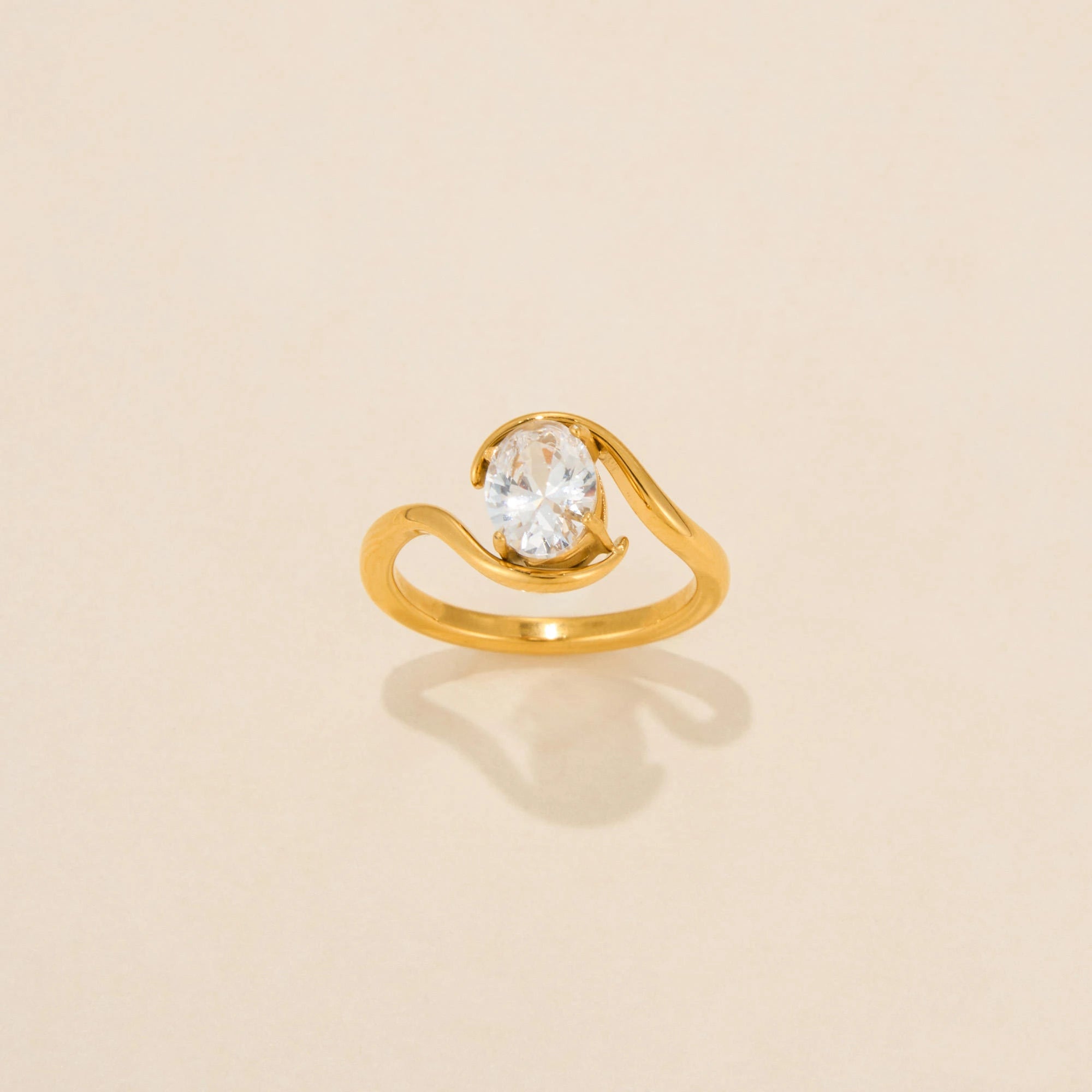 Gold ring with a diamond on a beige background