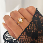 Gold ring with a large diamond on a hand wearing a black lace glove.