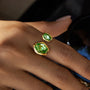 Gold rings with green gemstones on a person's fingers