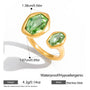 Gold ring with green gemstones and measurements on a white background