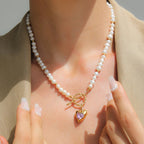 Pearl necklace with a gold clasp worn by a person, with a neutral background