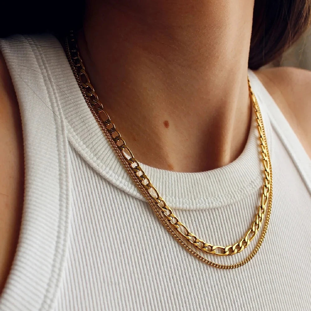 Gold chain necklace on a person wearing a white top