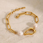 Gold chain bracelet with pearls on a beige surface