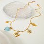 Gold bracelet with various charms on a white surface