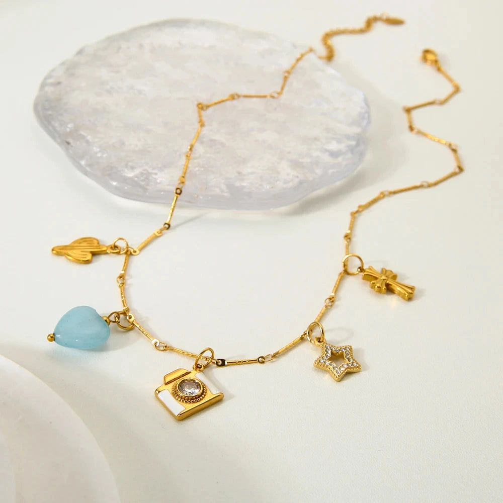 Gold bracelet with various charms on a white surface