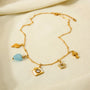 Gold necklace with various charms on a beige background