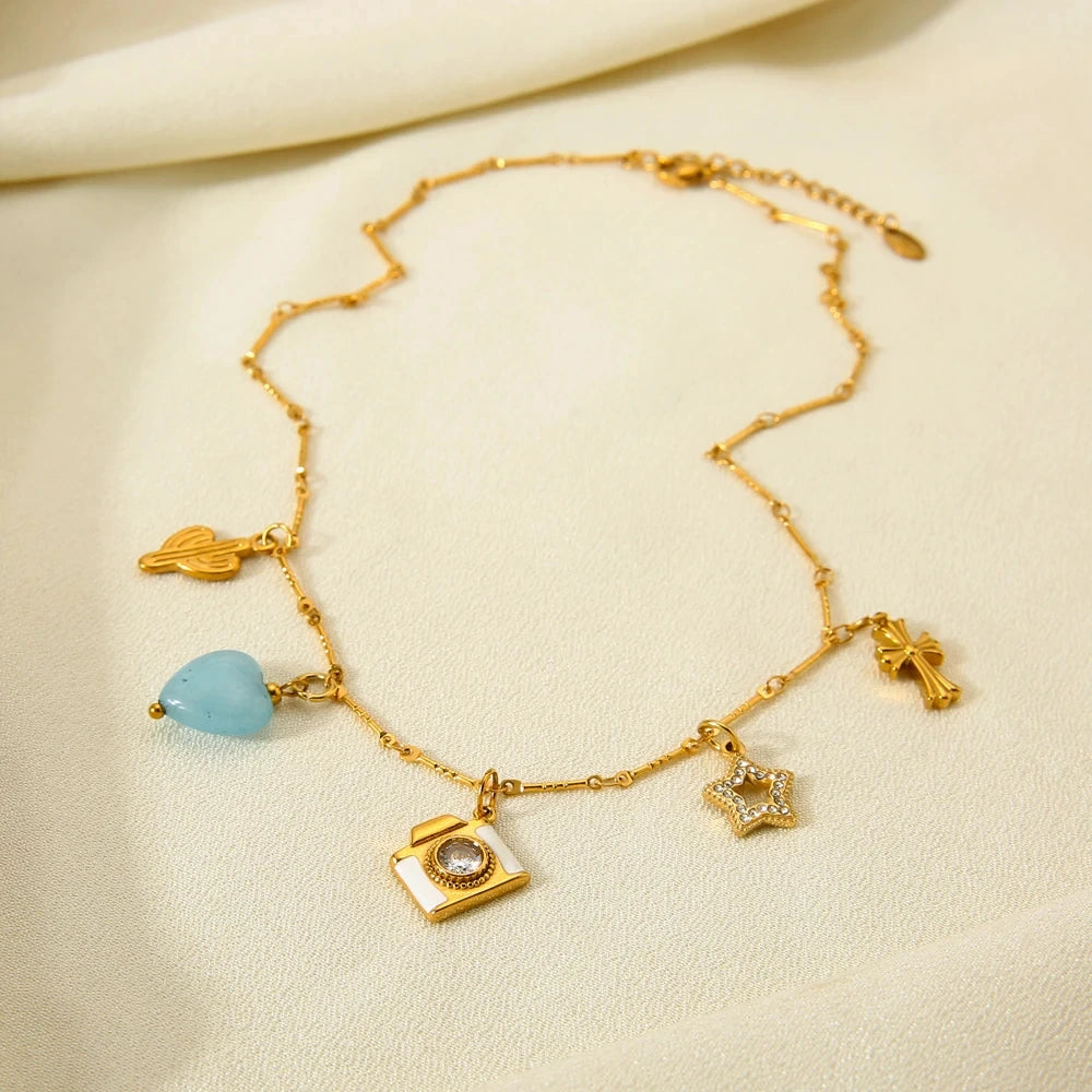 Gold necklace with various charms on a beige background