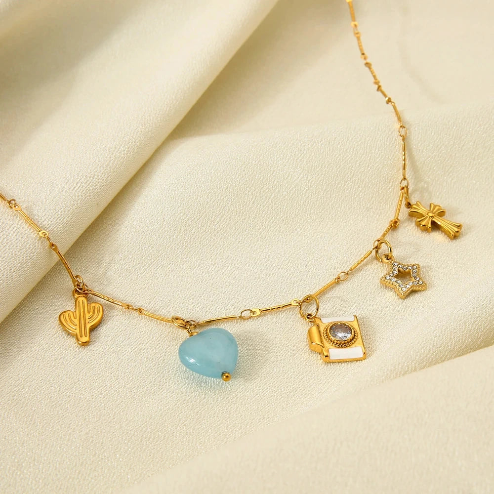 Gold necklace with charms on a beige fabric background