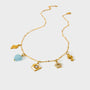 Gold necklace with various charms on a white background