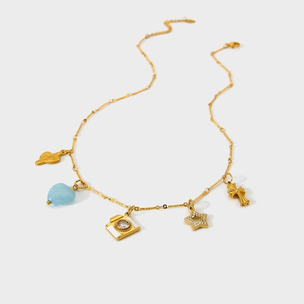 Gold necklace with various charms on a white background