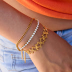 Close-up of a wrist wearing multiple gold bracelets with different designs.
