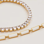 Gold bracelet with clear gemstones on a light beige background