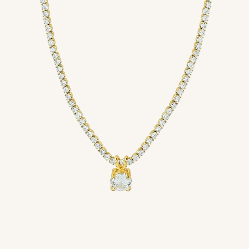 Gold necklace with a diamond pendant on a white background