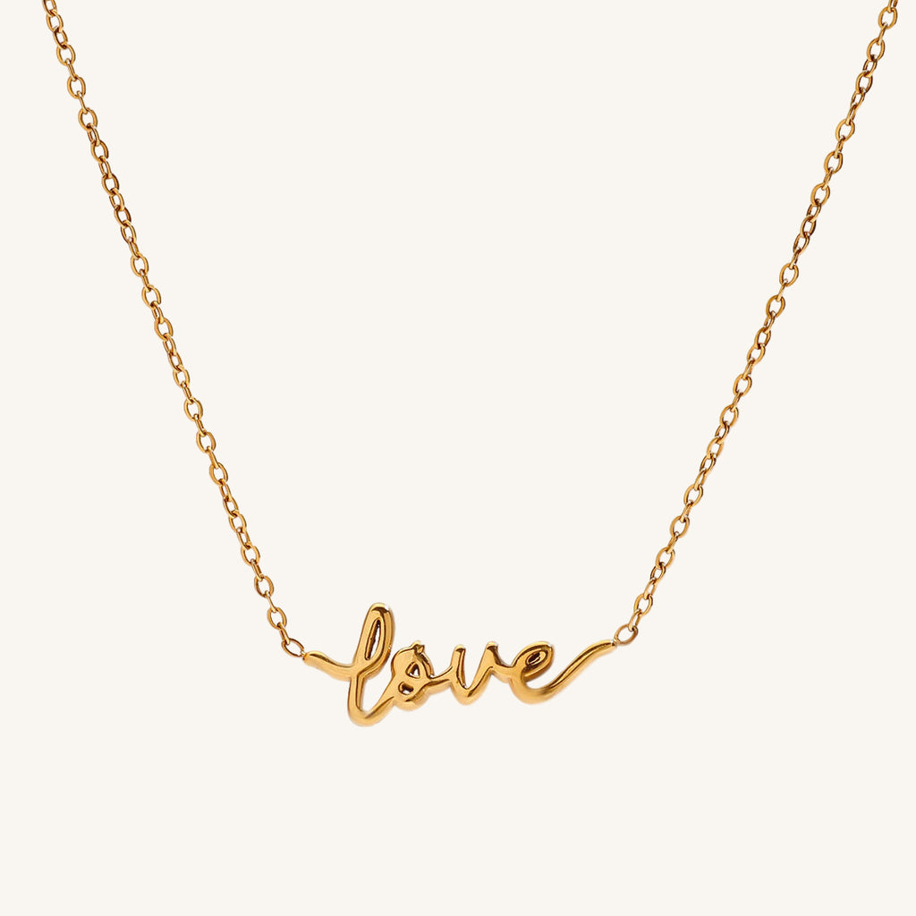 Gold necklace with 'love' pendant on a white background