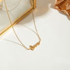 Gold necklace with 'love' pendant on a light background