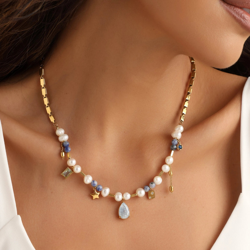 Necklace with pearls and gemstones worn by a person