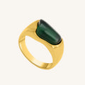 Gold ring with a green stone on a white background