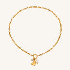 Gold bracelet with heart and pearl charm on a white background
