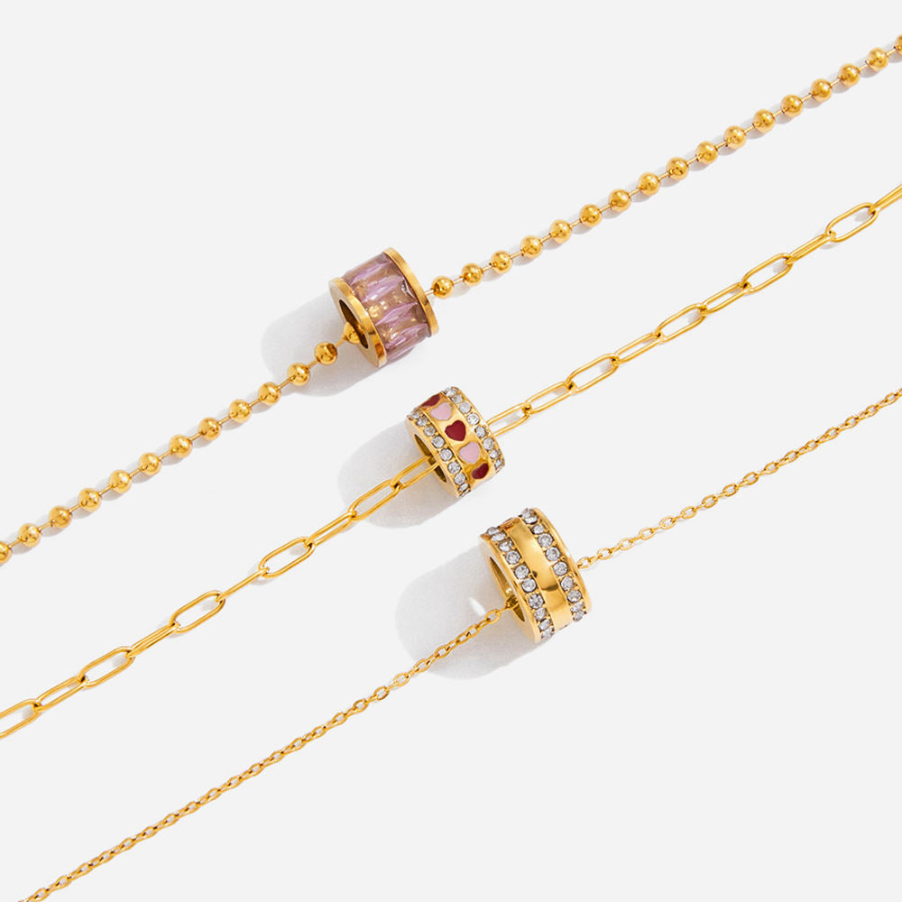 Gold chain with decorative beads on a white background
