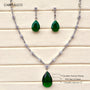 Jewelry set with green teardrop pendants and chain on a wooden surface, featuring Carryllco branding.