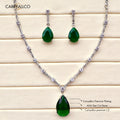 Jewelry set with green teardrop pendants and chain on a wooden surface, featuring Carryllco branding.