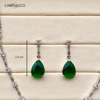 Green teardrop earrings with silver accents on a wooden surface, featuring the brand 'CARRYALLCO'.
